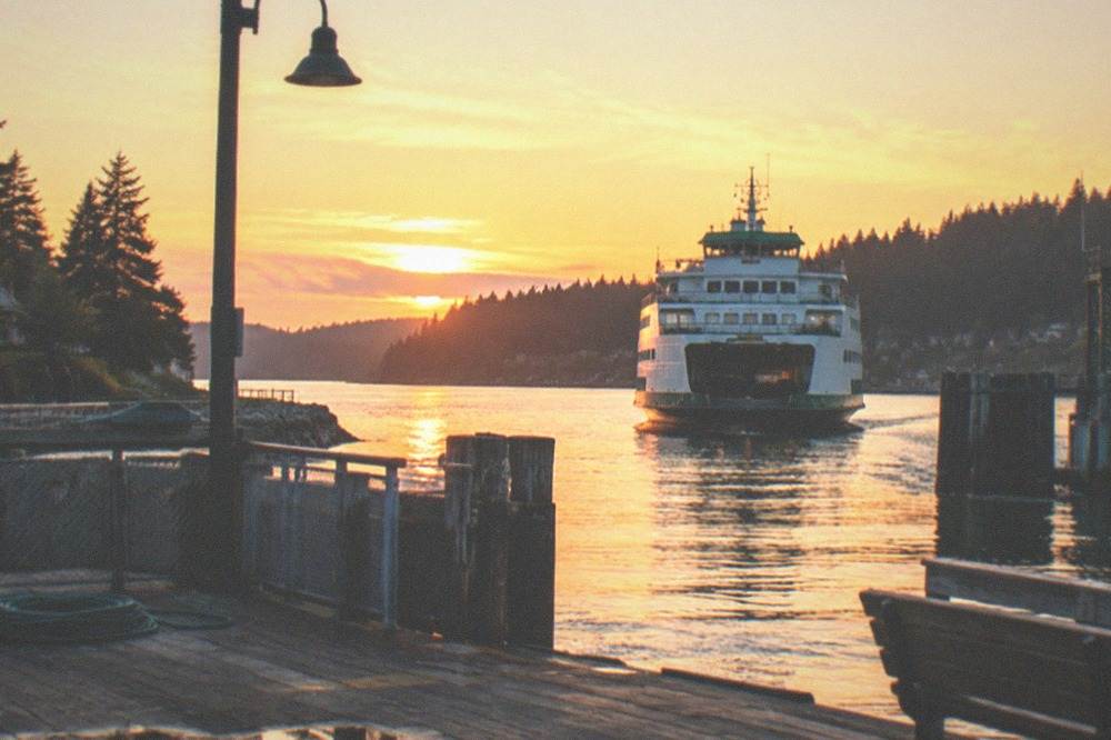 Golden sunset light over Puget Sound with a ferry crossing toward Bainbridge Island