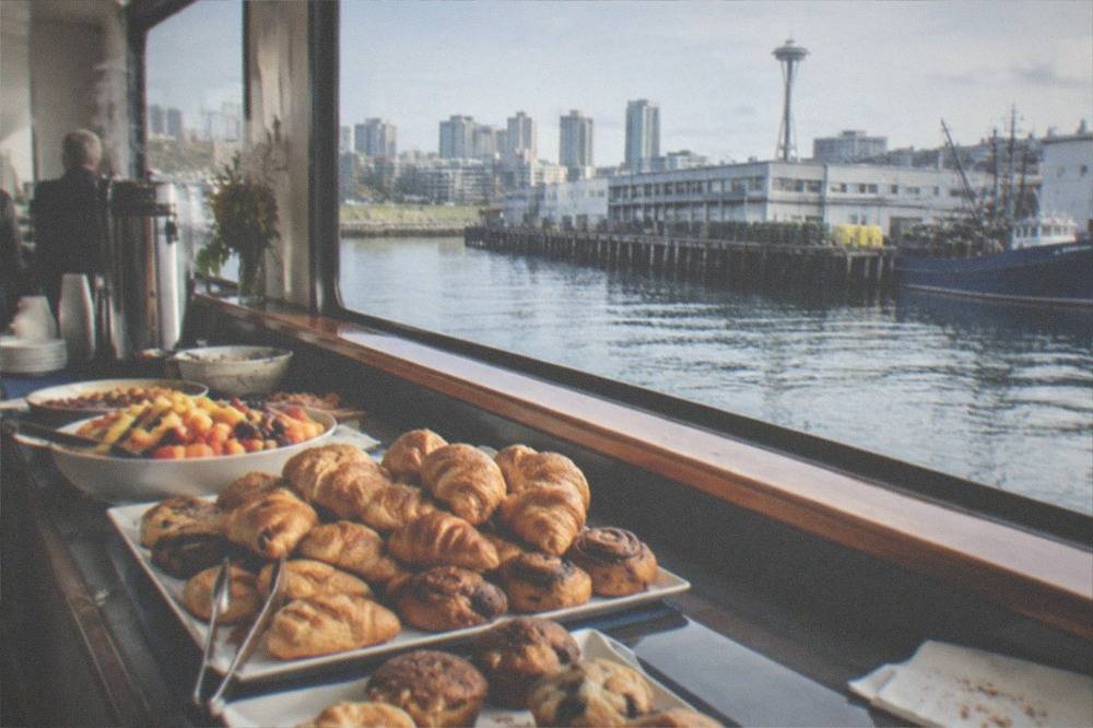 A brunch buffet table with pastries and fruit arranged along a boat salon counter
