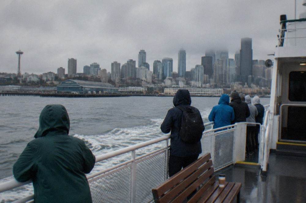 A whale-watching boat leaving Elliott Bay with the Seattle skyline behind it